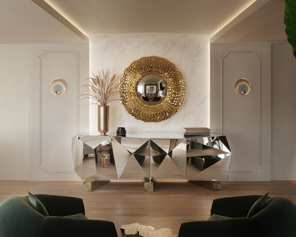 living area with big silver sideboard, round golden mirror in the wall and two green armchairs