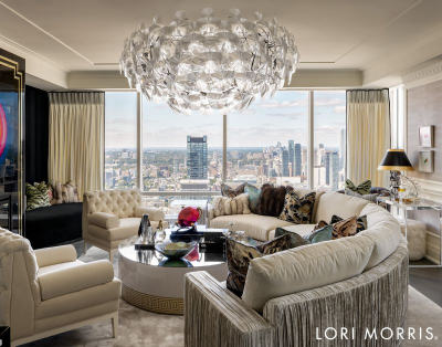 Lori Morris Design - Living room design with a classic touch, a round sofa, two armchairs, a center table and a suspension lamp. All in neutral tones and a view to the city.